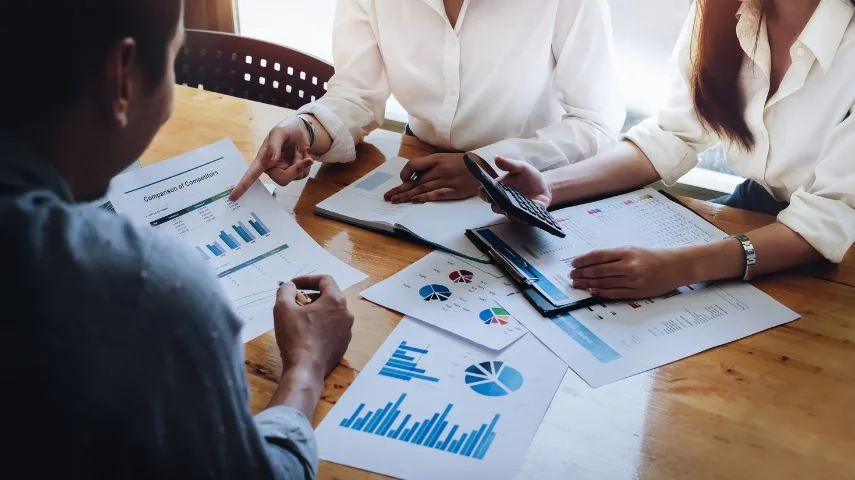 Business meeting analyzing financial charts and graphs.