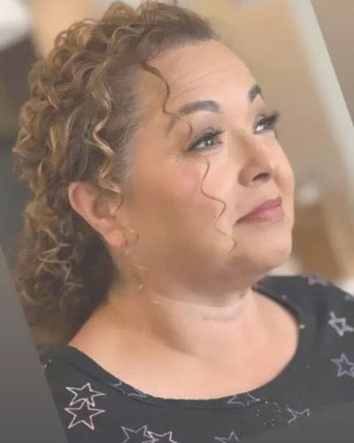 Smiling woman with curly hair looking upwards